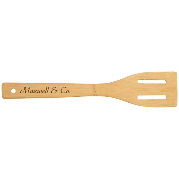 Wooden cooking spatula with a name wood burned on the handle.