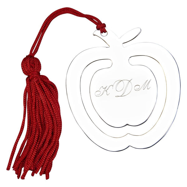 Monogrammed shiny silver apple shaped bookmark with a red tassel.