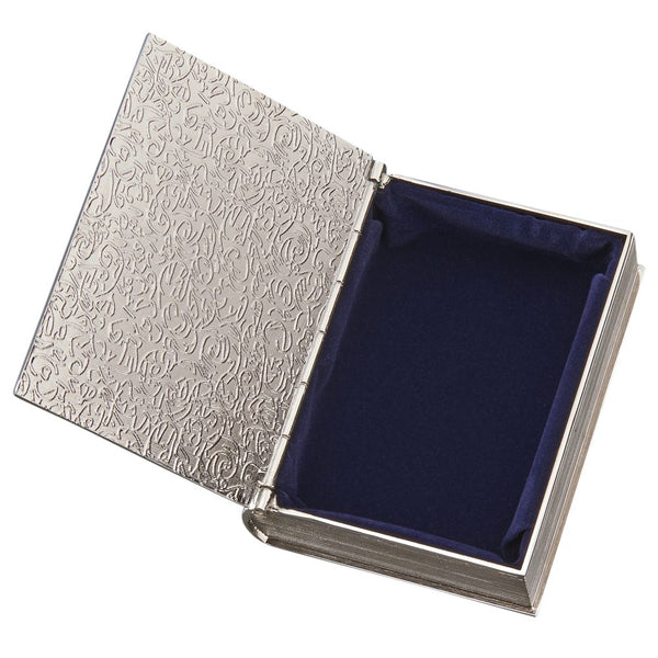 Small silver book shaped keepsake box with a hinged cover. The front of the box features a border, a cross, and a name engraved at the bottom.The edges are designed to look like the spine and pages of a book. The inside is lined in navy blue velvet material.