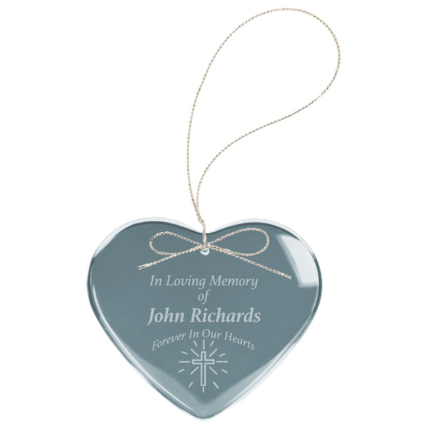 Crystal heart shaped ornament with silver string and bow for hanging. Heart ornament is engraved with a memorial piece and cross in a frosty white color.
