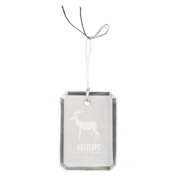 Rectangle shaped crystal ornament that is faceted on the sides and is engraved with an antelope in the center in a frosty white color. A silver string is attached at the top for hanging.