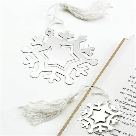 Shiny silver flat snowflake shaped bookmark with a white tassel. The center of the bookmark can be engraved with a special message.
