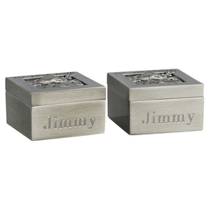Two small square silver boxes with lids that feature a teddy bear. On the lid of each box reads "My First Tooth" or "My First Curl" in black letters. A name is engraved on the side of each of the boxes.