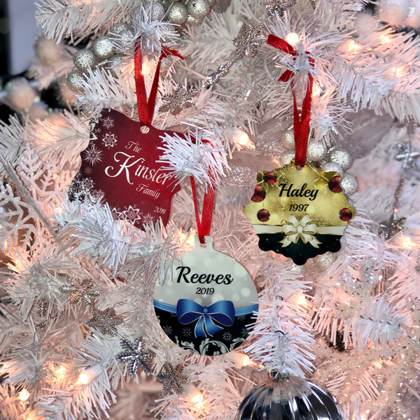 White Christmas tree holding different shaped ornaments with different colors and designs on each. 