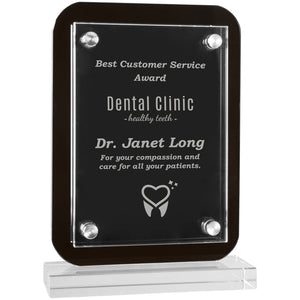 Standing black glass plaque featuring a rectangle shape and rounded edges. The base is clear glass rectangle shaped. There is a clear piece of engraved acrylic overlaid on the glass plaque that is secured by magnets on all four corners.