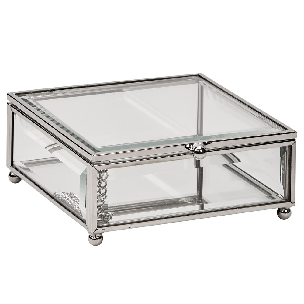 Rectangle shaped glass jewelry box with silver edges and corners and round feet.