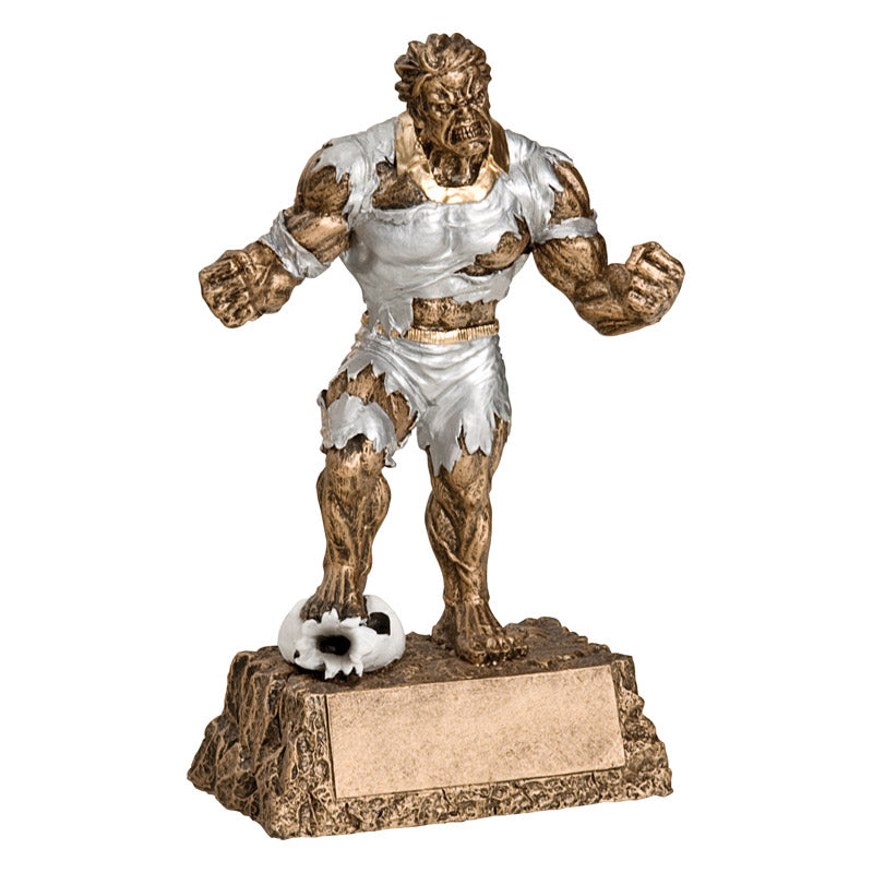Hulk inspired soccer trophy featuring a bronze rectangle base that resembles rocks, and a bronze monster busting out of ripped silver clothes. He is stepping on a flattened soccer ball with his hands in fists.