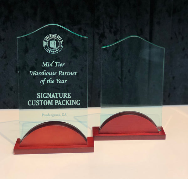 Small and large jade colored engraved standing acrylic awards with a cherry wood colored base.