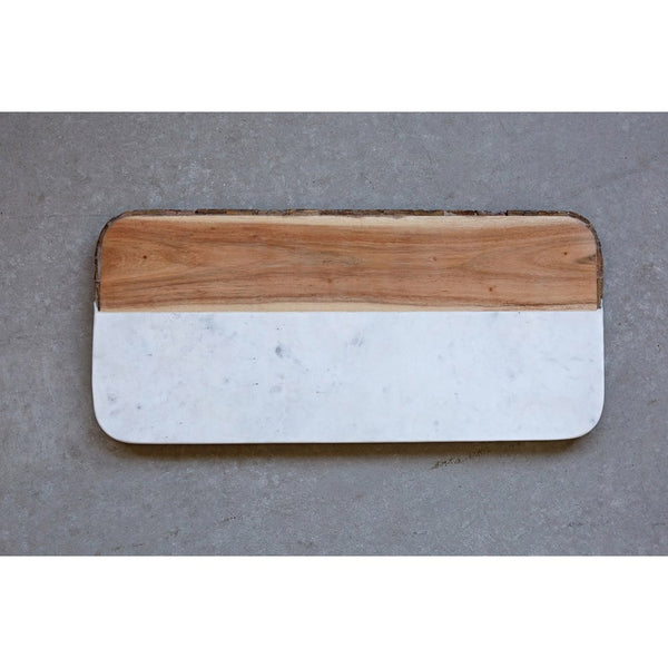 Wood and marble cutting board featuring a bark edge where the wood is. Cutting board is rectangle shaped with curved edges and is a little over half marble. Marble slab meets light wood horizontally with a real bark edge.