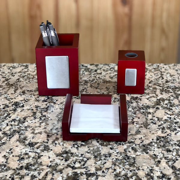 Cherry wood colored pen holder, paper clip holder and memo holder all featuring silver plates on the front that can be personalized for an office.