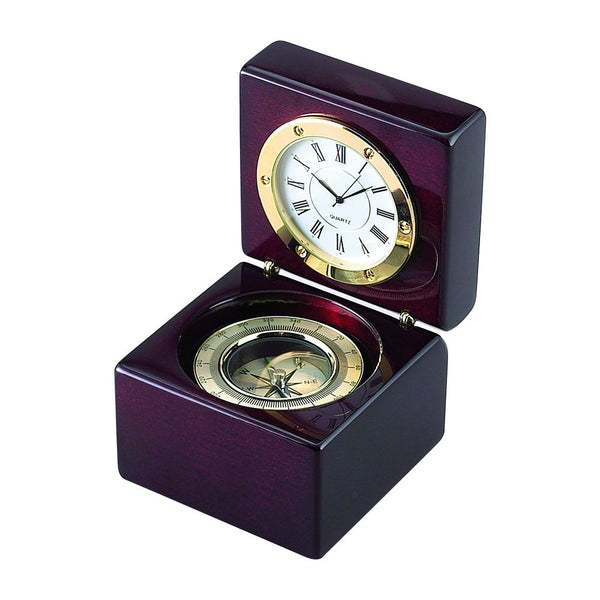 High gloss rosewood hinged box featuring a compass in the bottom half and a clock on  the top half when opened. The clock and compass are outlined in gold. The clock has a white face with black hands and roman numerals.