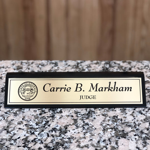 Black and gold personalized desk name plate.