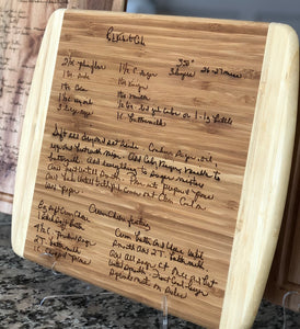 Large rectangle shaped light wood cutting board featuring two curved ends that are a lighter wood than the center. The center of the cutting board is engraved with a hand written recipe wood burned into the cutting board.